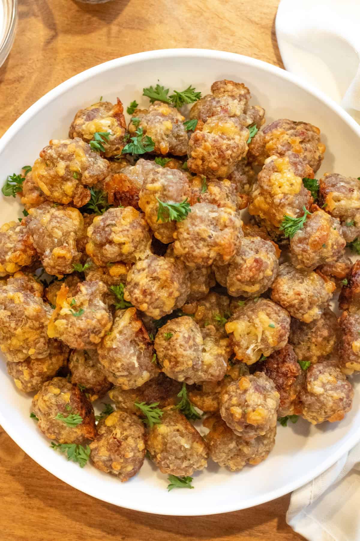 an overhead of a bowl of mini cheesy meatballs.