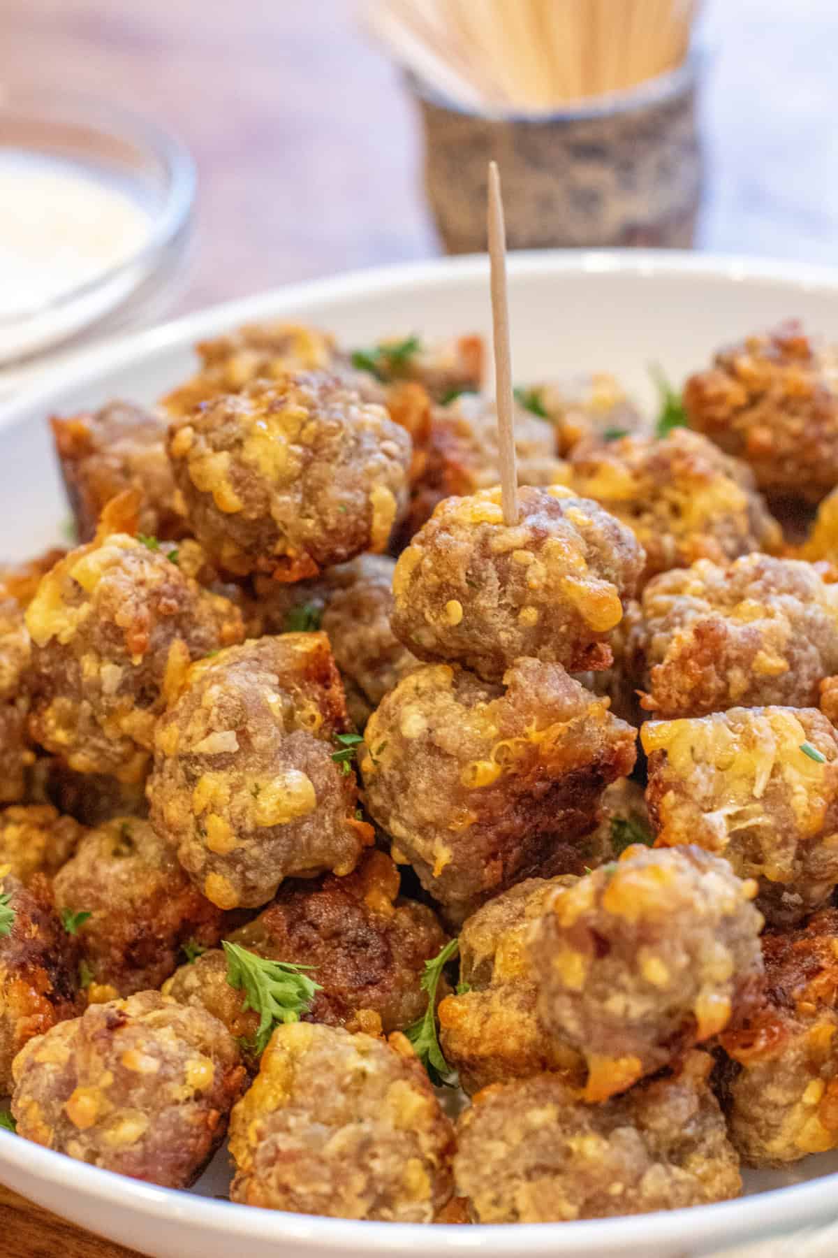 a bowl of sausage balls with one with a toothpick.