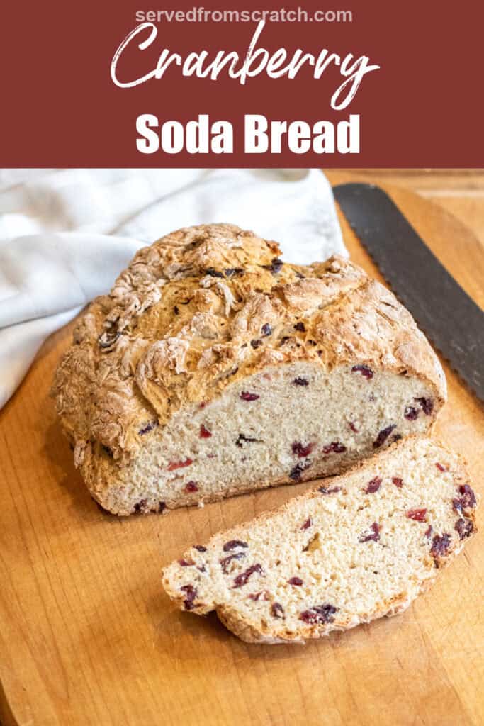a loaf of bread with cranberries and a slice cut off with a bread knife with Pinterest pin text.