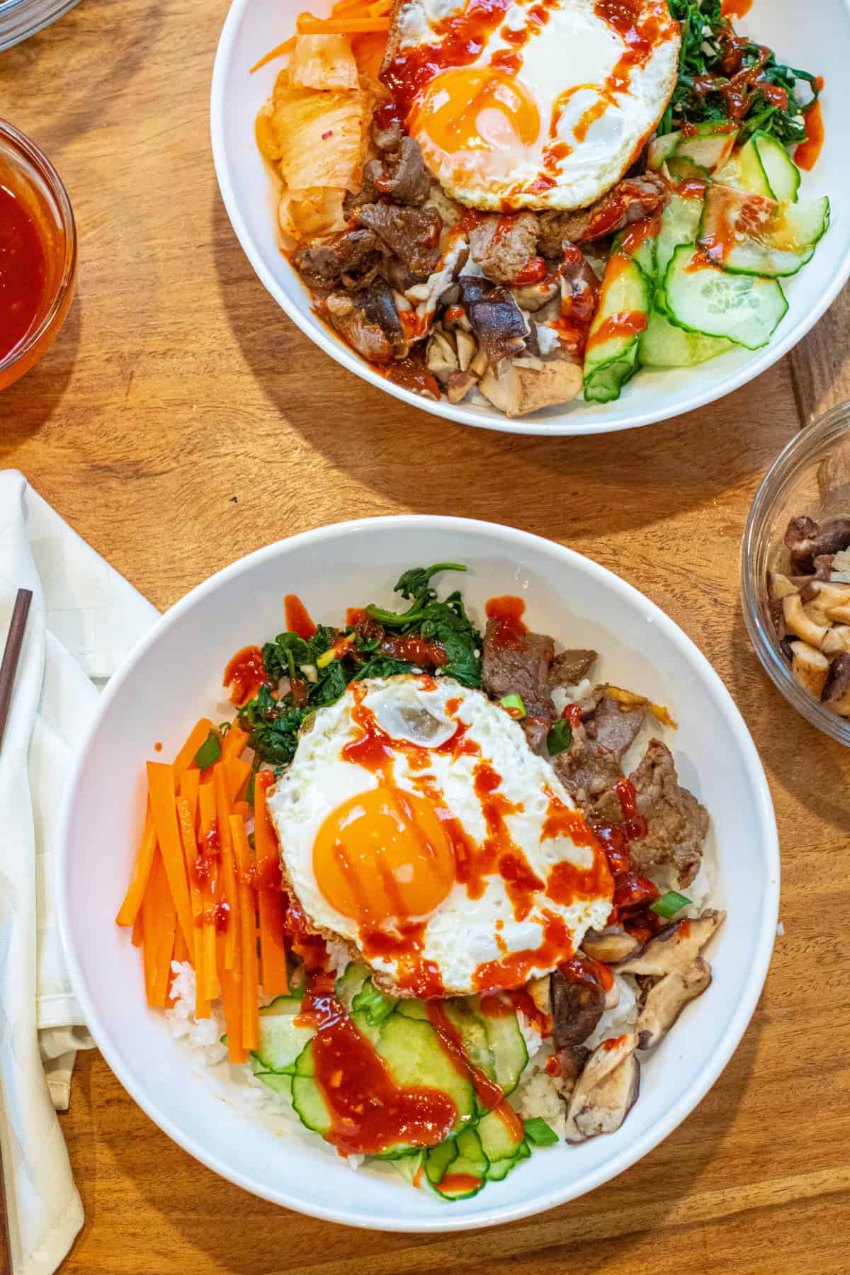 an overhead of a table with bowls of bibimbap and sides.