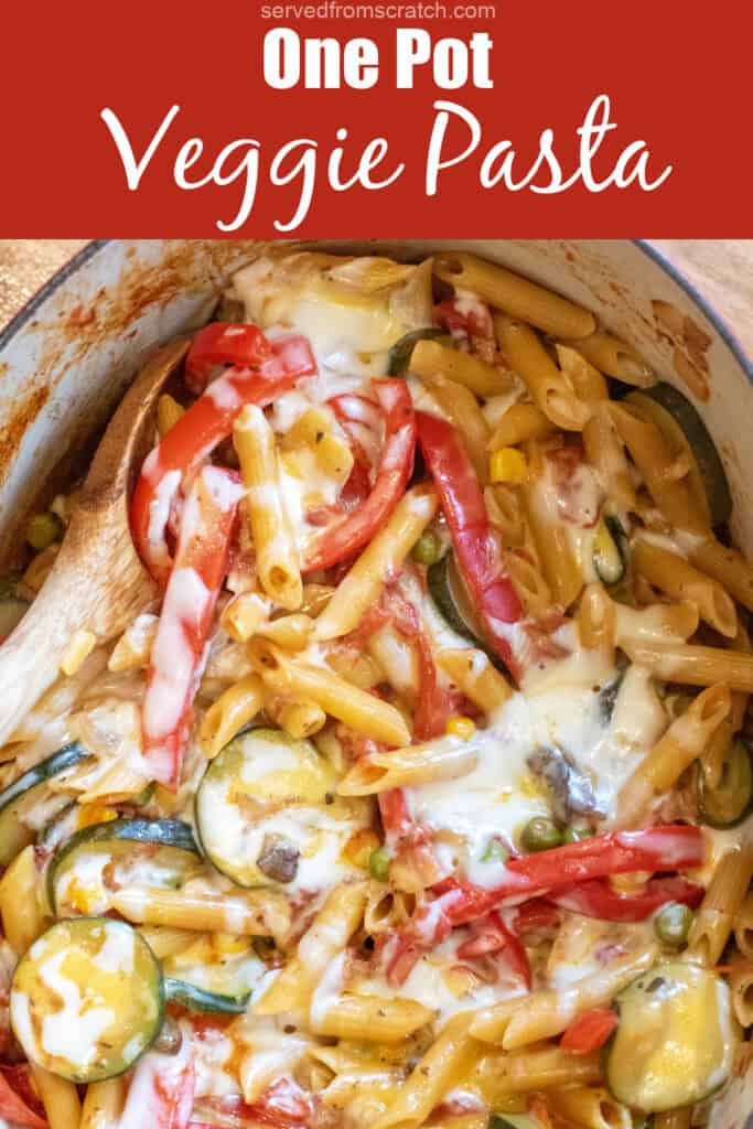 an overhead of cheesy pasta with veggies with a wooden spoon in it with Pinterest pin text.