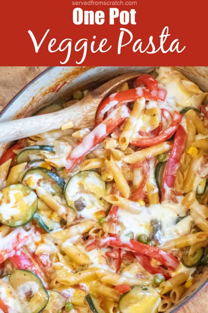 an overhead of cheesy pasta with veggies with a wooden spoon in it with Pinterest pin text.