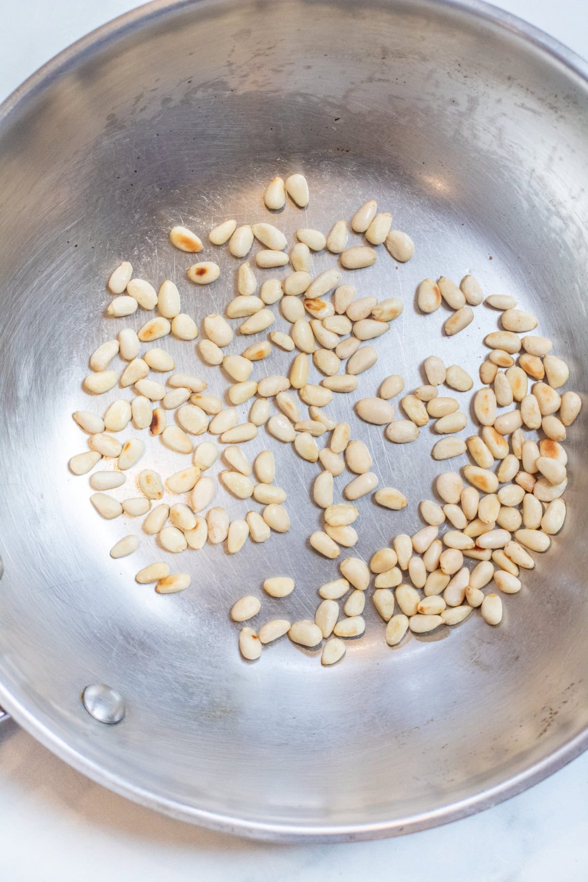 a saute pan with toasted pine nuts.