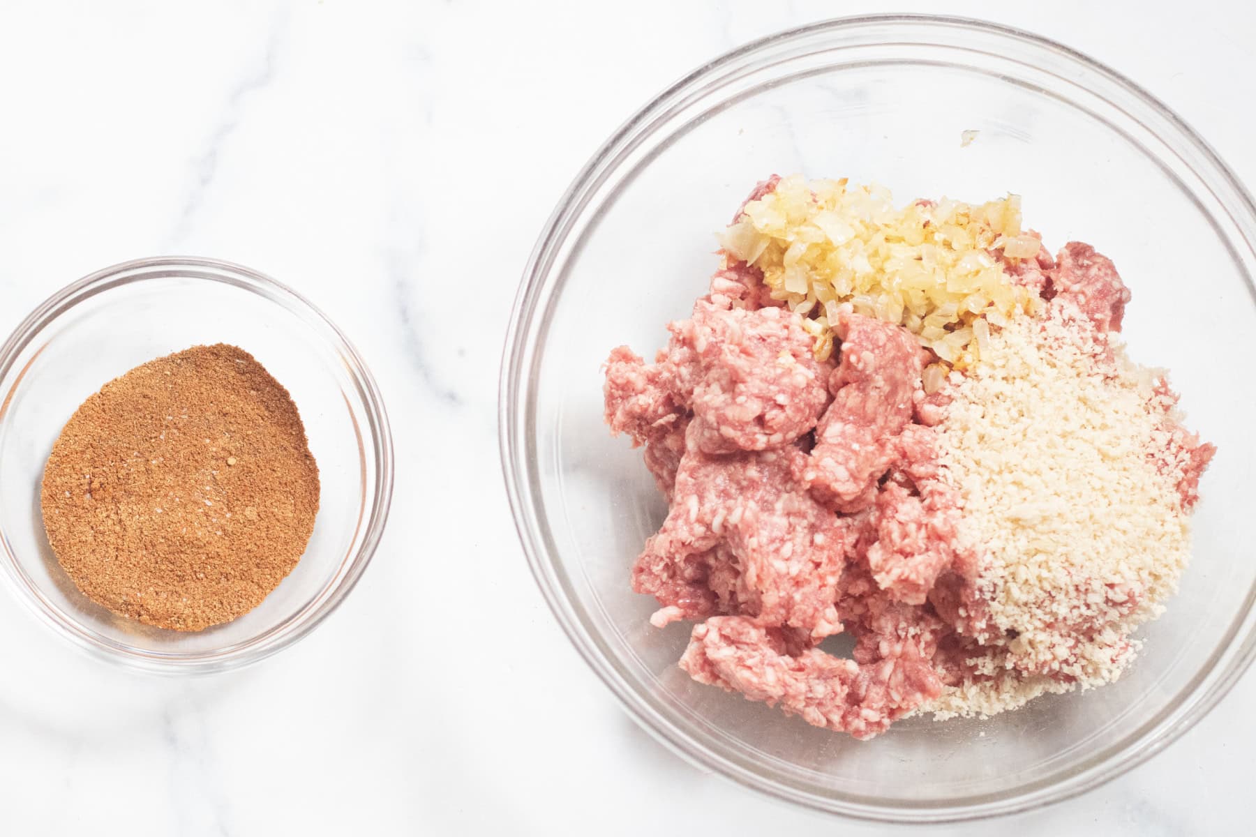 a bowl of spices and a bowl of ground lamb with panko and sautéed onion and garlic.