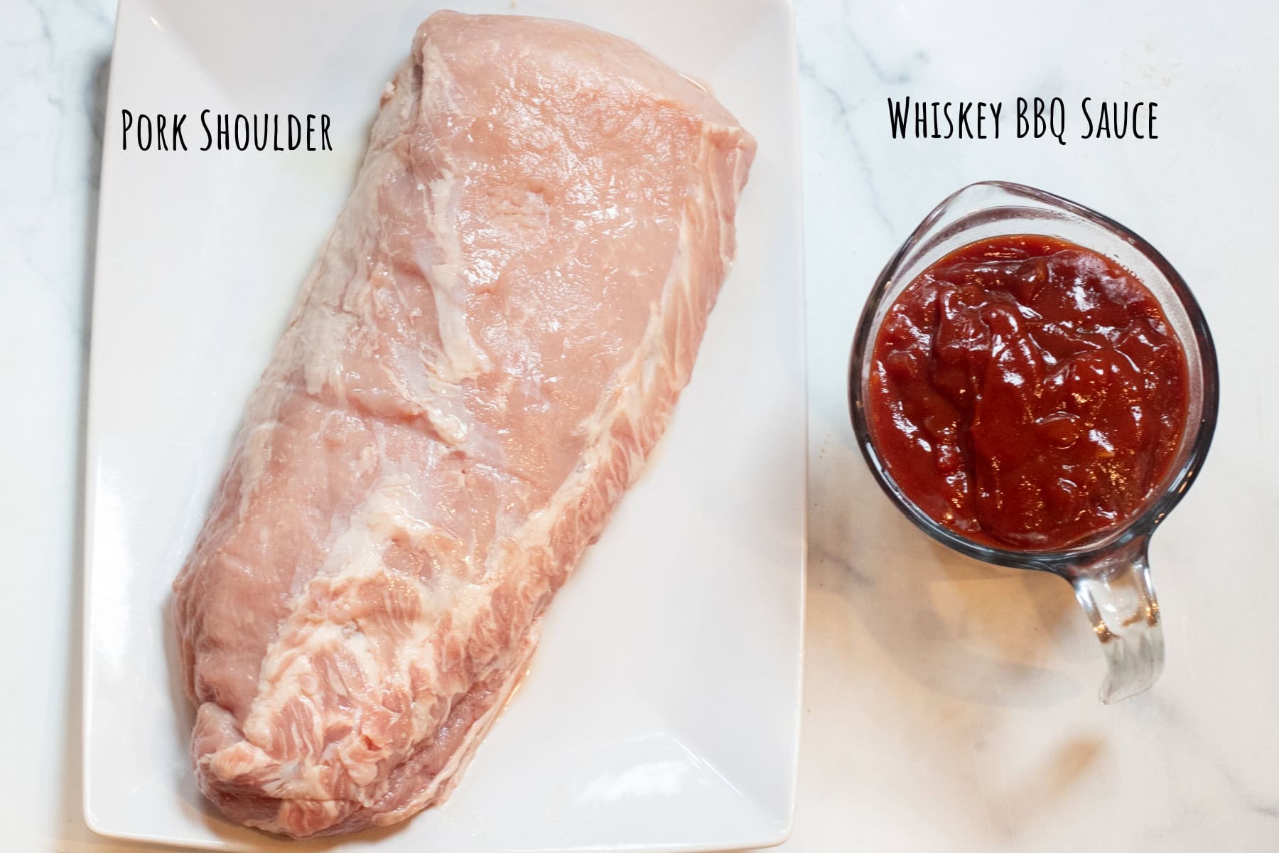 a large raw pork shoulder and a Pyrex with BBQ sauce.