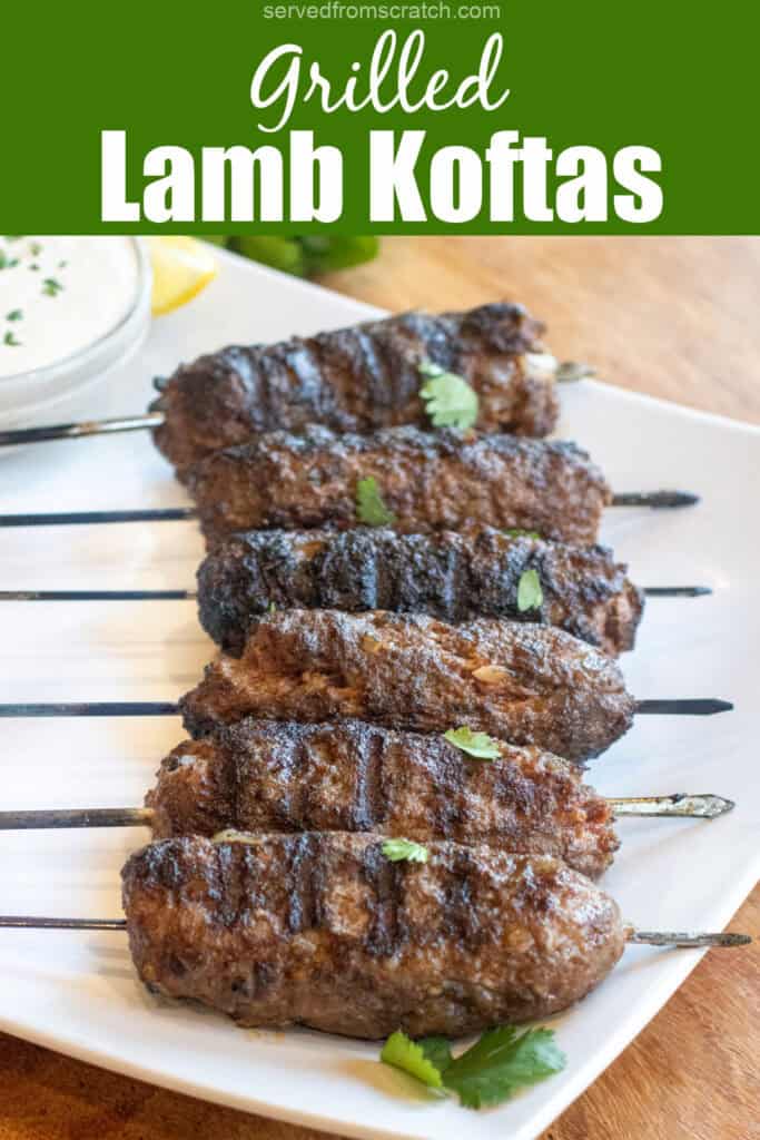 grilled cooked kofta skewers on a plate with a bowl of yogurt sauce and some cilantro with Pinterest pin text.