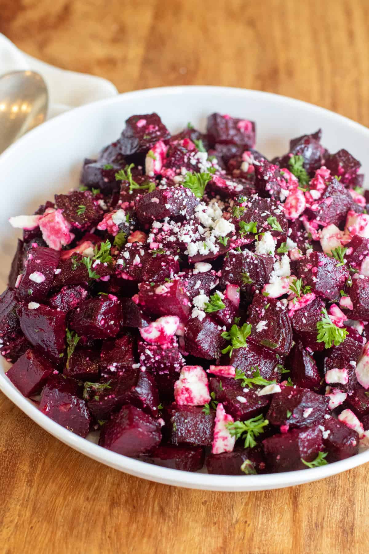 a bowl of cubed and roasted beets with feta and herbs.