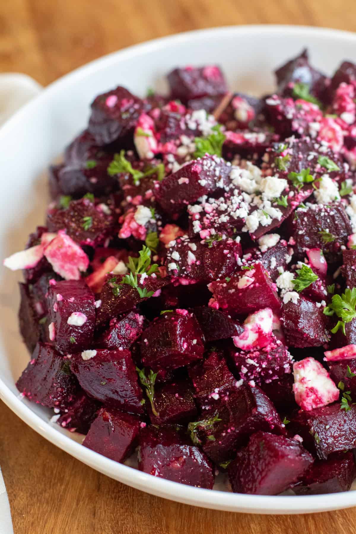 a bowl of cubed and roasted beets with feta and herbs.