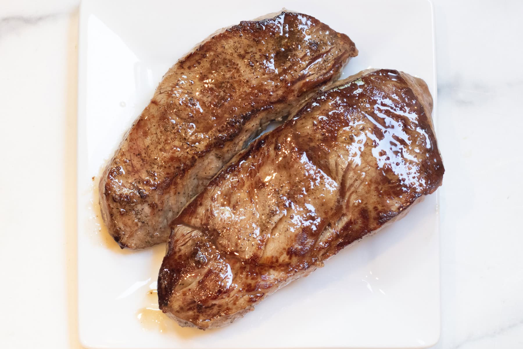 cooked steaks on a plate.