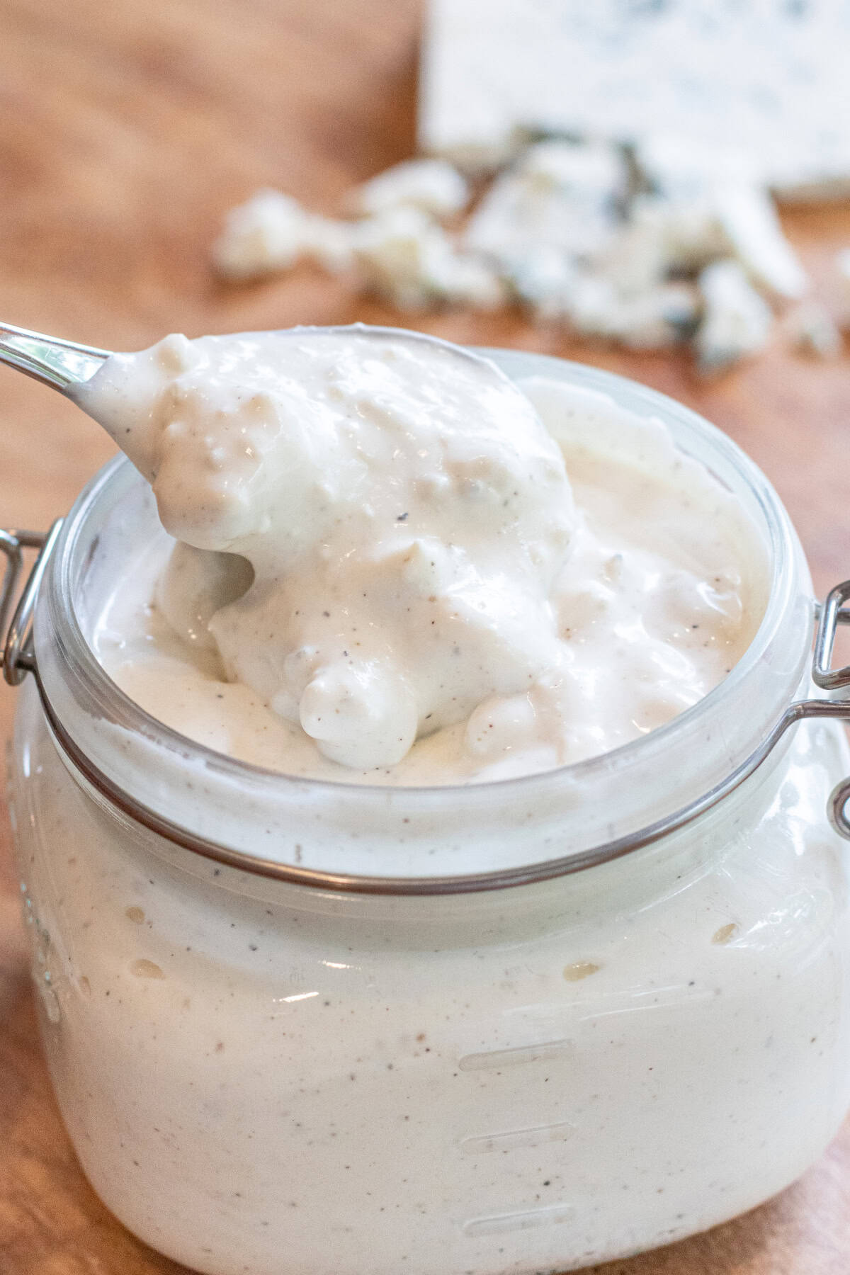 an open mason jar of blue cheese with a spoon coming out of it.