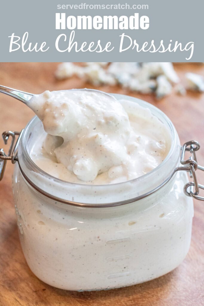 an overhead of an open mason jar of creamy chunky blue cheese dressing with a spoon in it with Pinterest pin text.