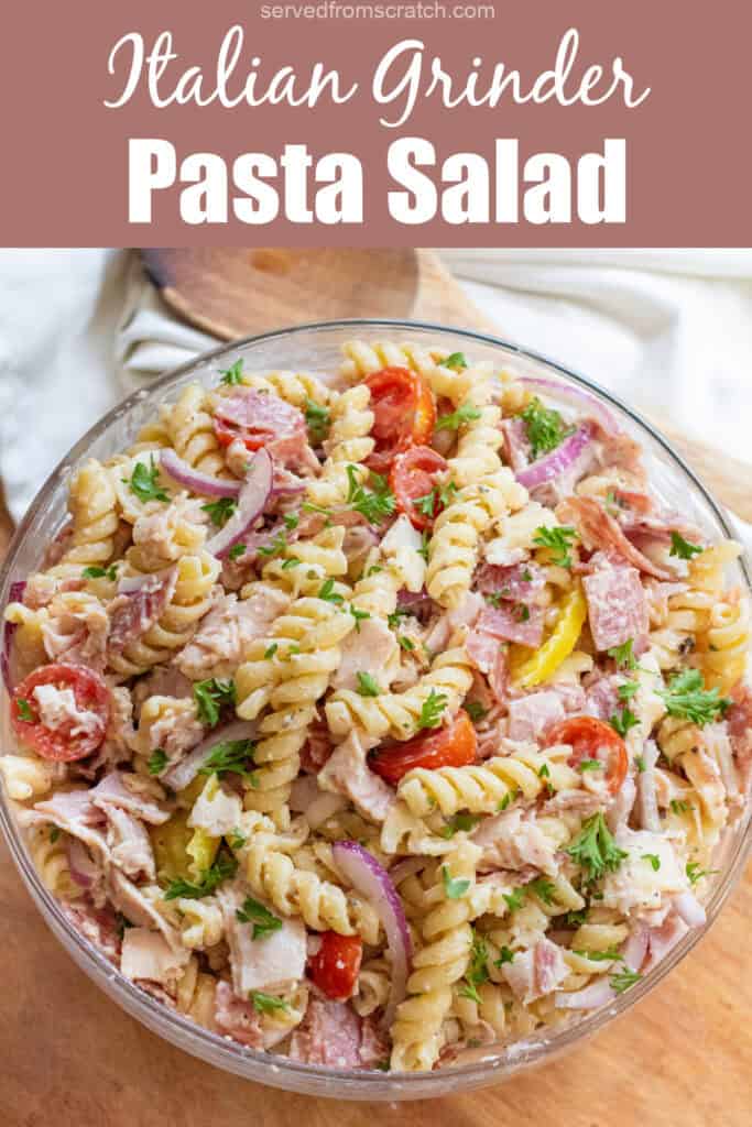 an overhead of a pasta salad with meats, cheese, tomatoes, parsley, and banana peppers with Pinterest pin text.