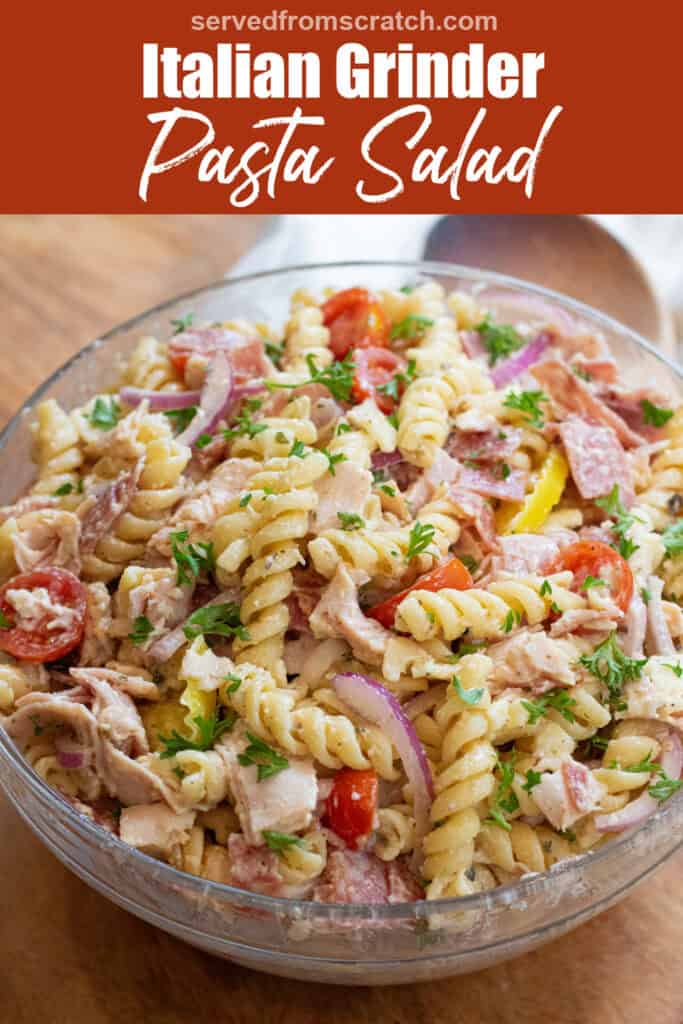 an overhead of a pasta salad with meats, cheese, tomatoes, parsley, and banana peppers with Pinterest pin text.