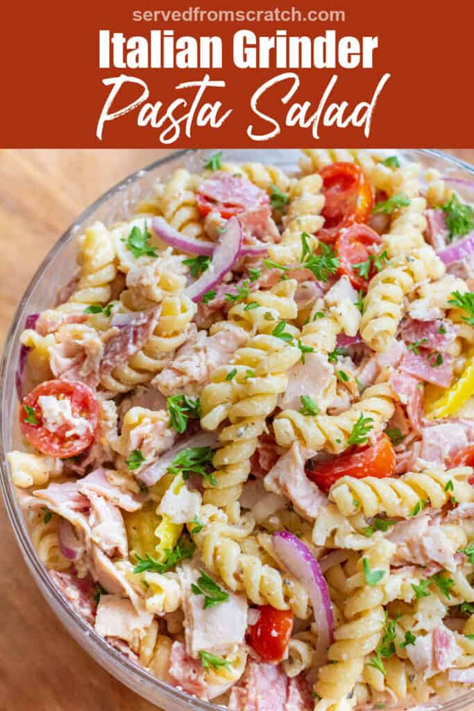 an overhead of a pasta salad with meats, cheese, tomatoes, parsley, and banana peppers with Pinterest pin text.