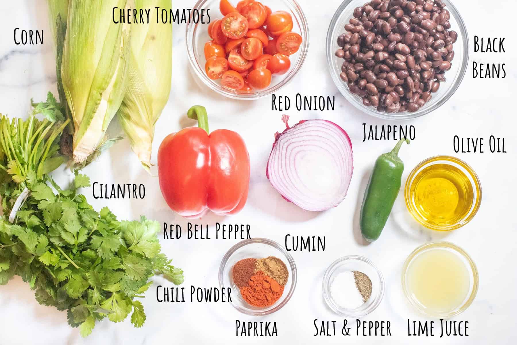 corn on the cob, cilantro, halved cherry tomatoes, a bowl of black beans, red pepper, halved red onion, jalapeno, olive oil, lime juice, spices, salt and pepper all labeled.