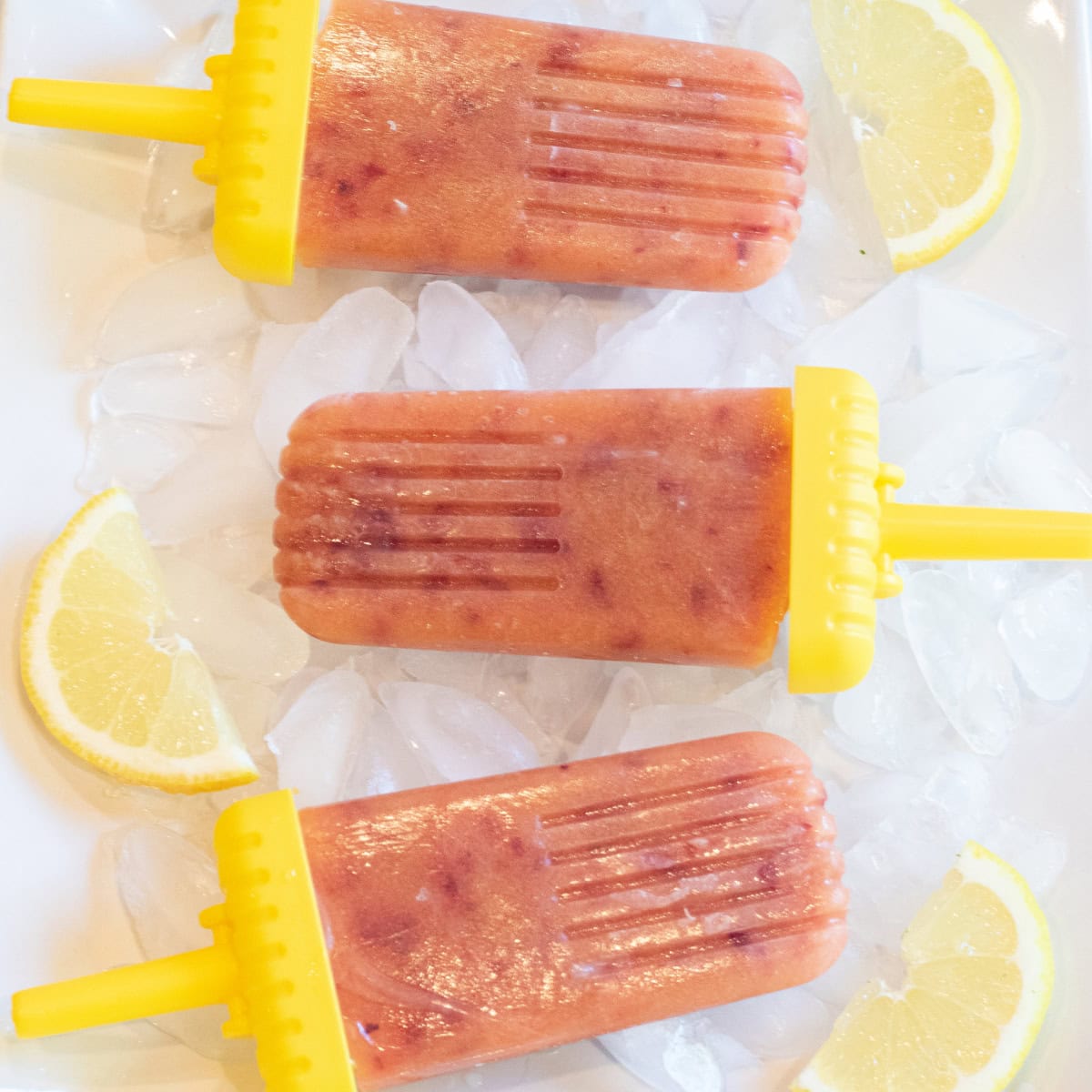 a plate of peach popsicles and lemon slices.