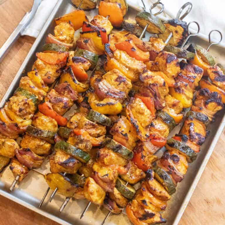 a tray of cooked chicken and pepper kebabs.
