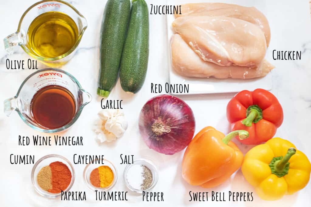 raw chicken, zucchini, bell peppers, oil, vinegar, spices, garlic, and onion labeled.