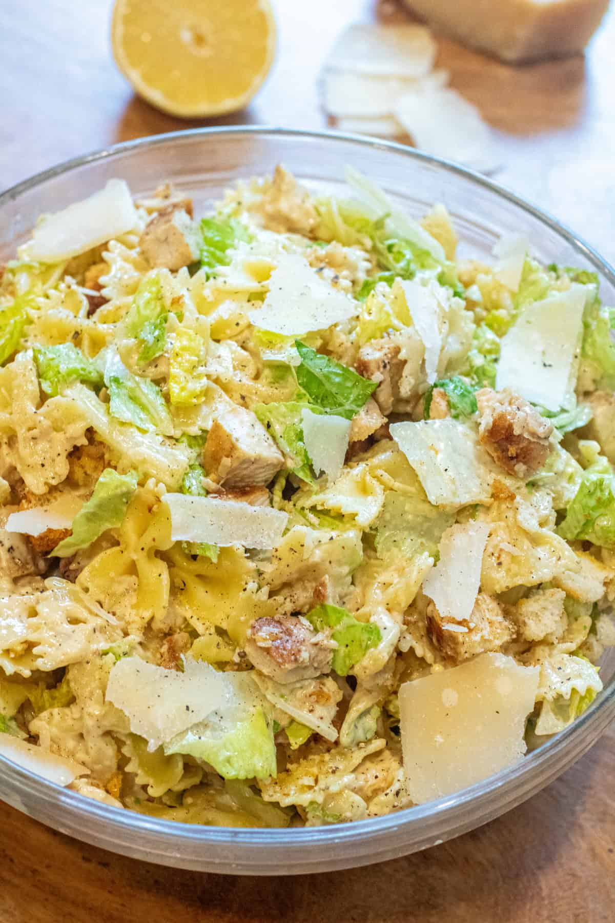 an overhead of a pasta salad with lettuce, chicken, croutons, and cheese.