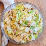 an overhead of a pasta salad with lettuce, chicken, croutons, and cheese.