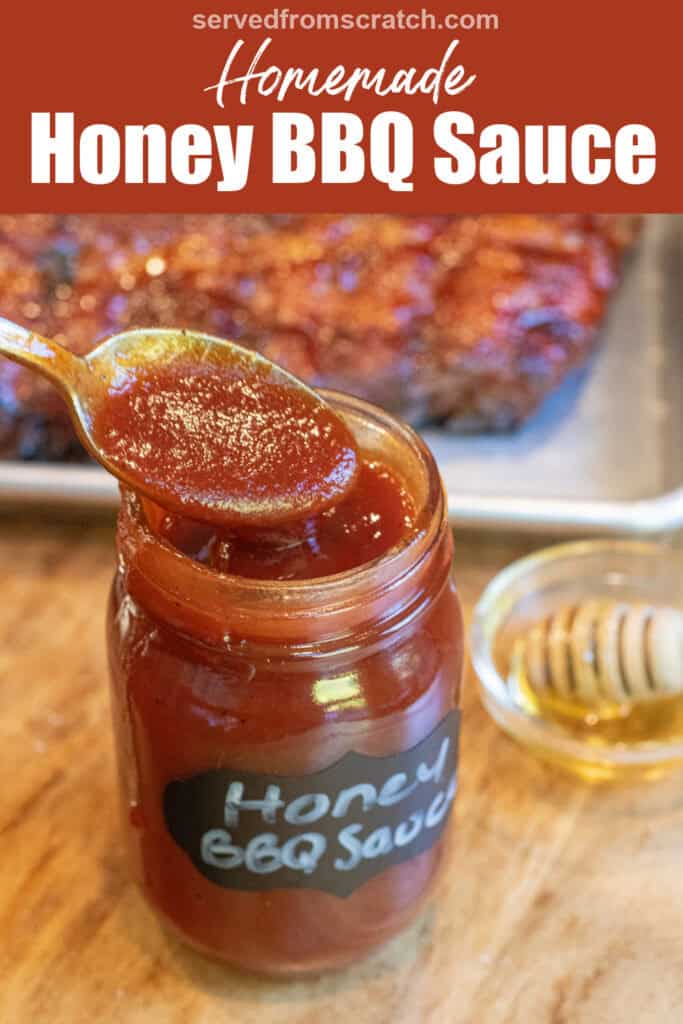 an open jar of honey bbq sauce with a spoon in front of a tray of ribs with Pinterest pin text.