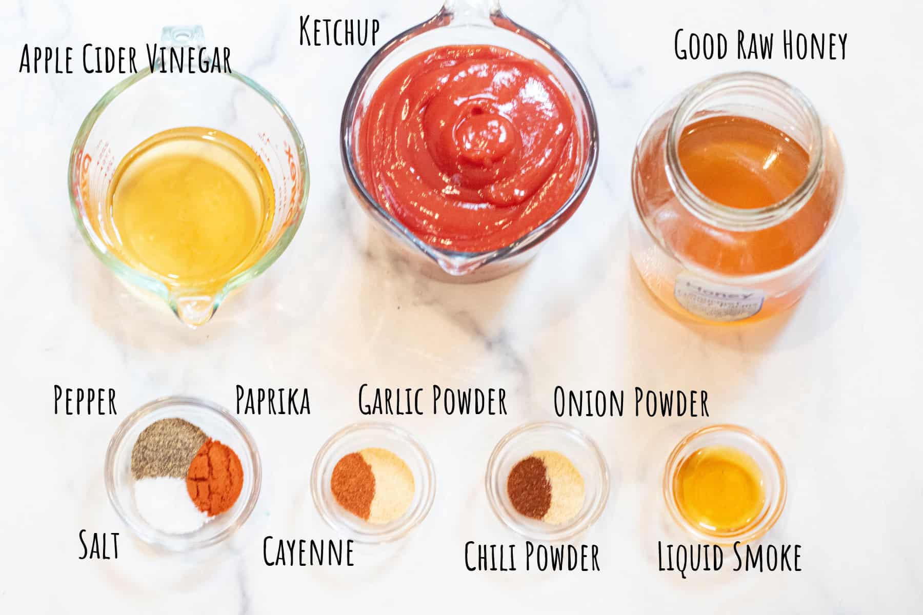 bowls of ketchup, vinegar, a jar of honey, and small bowls of spices and liquid smoke labeled.
