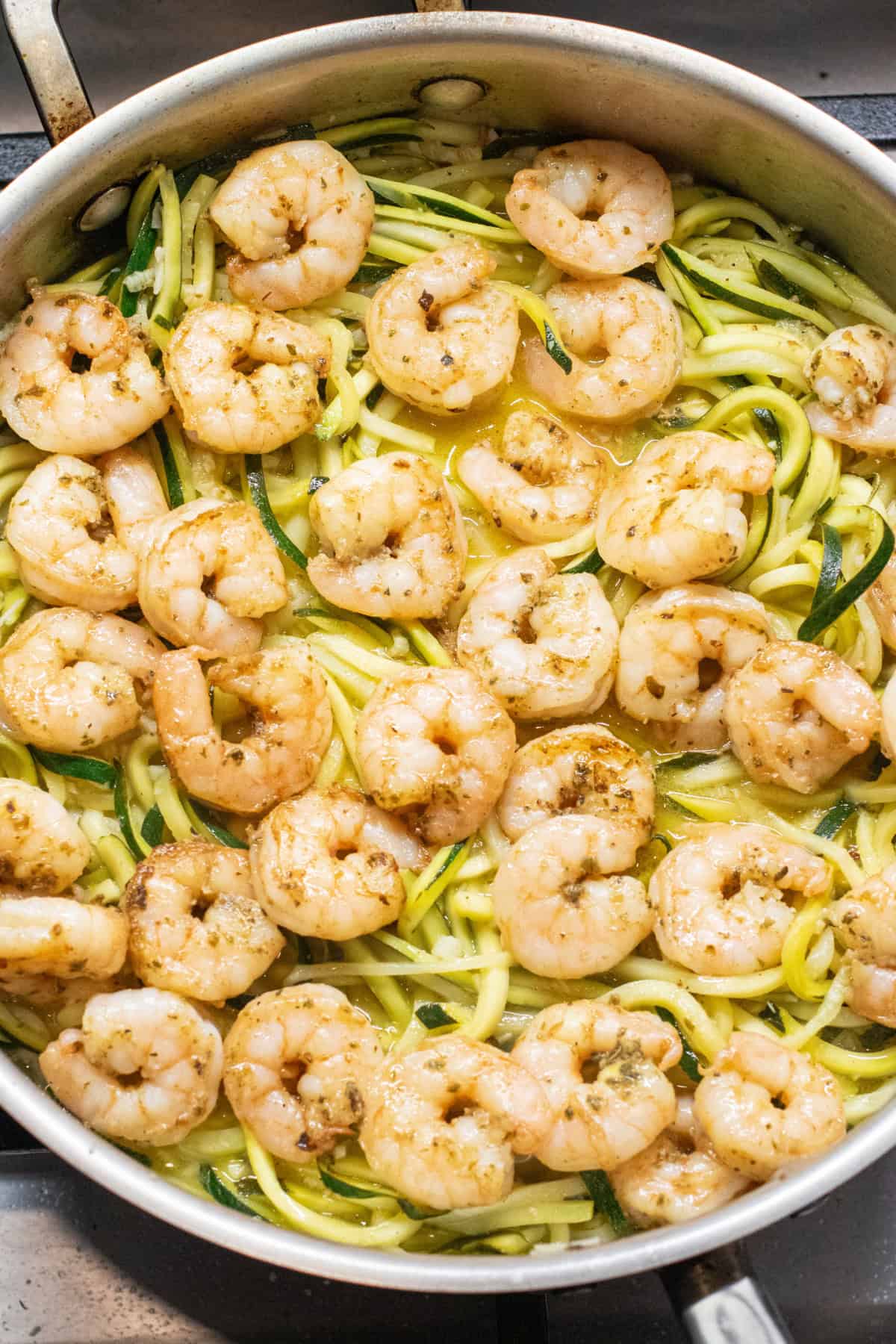 a pan of cooked zoodles and shrimp.