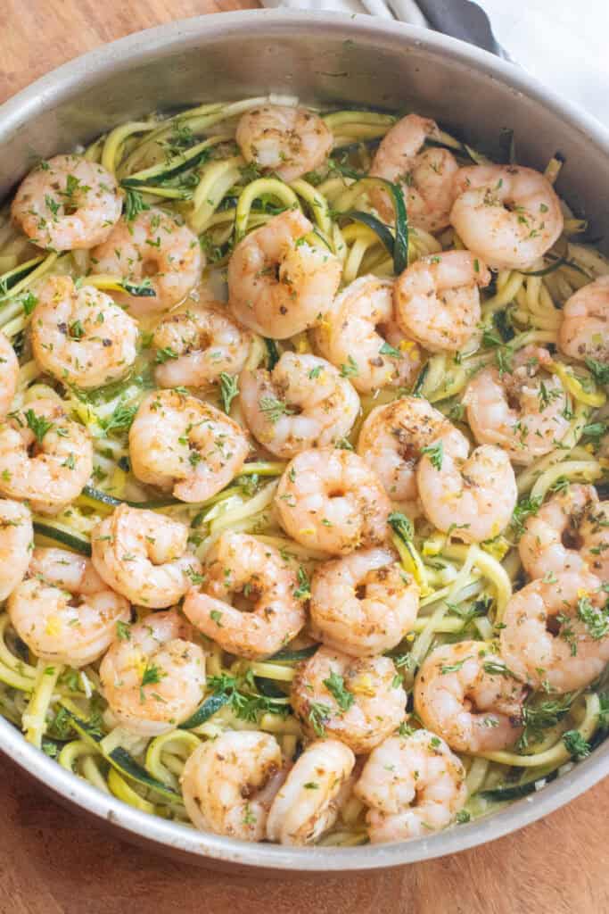 an overhead of a pan with cooked shrimp and zoodles.