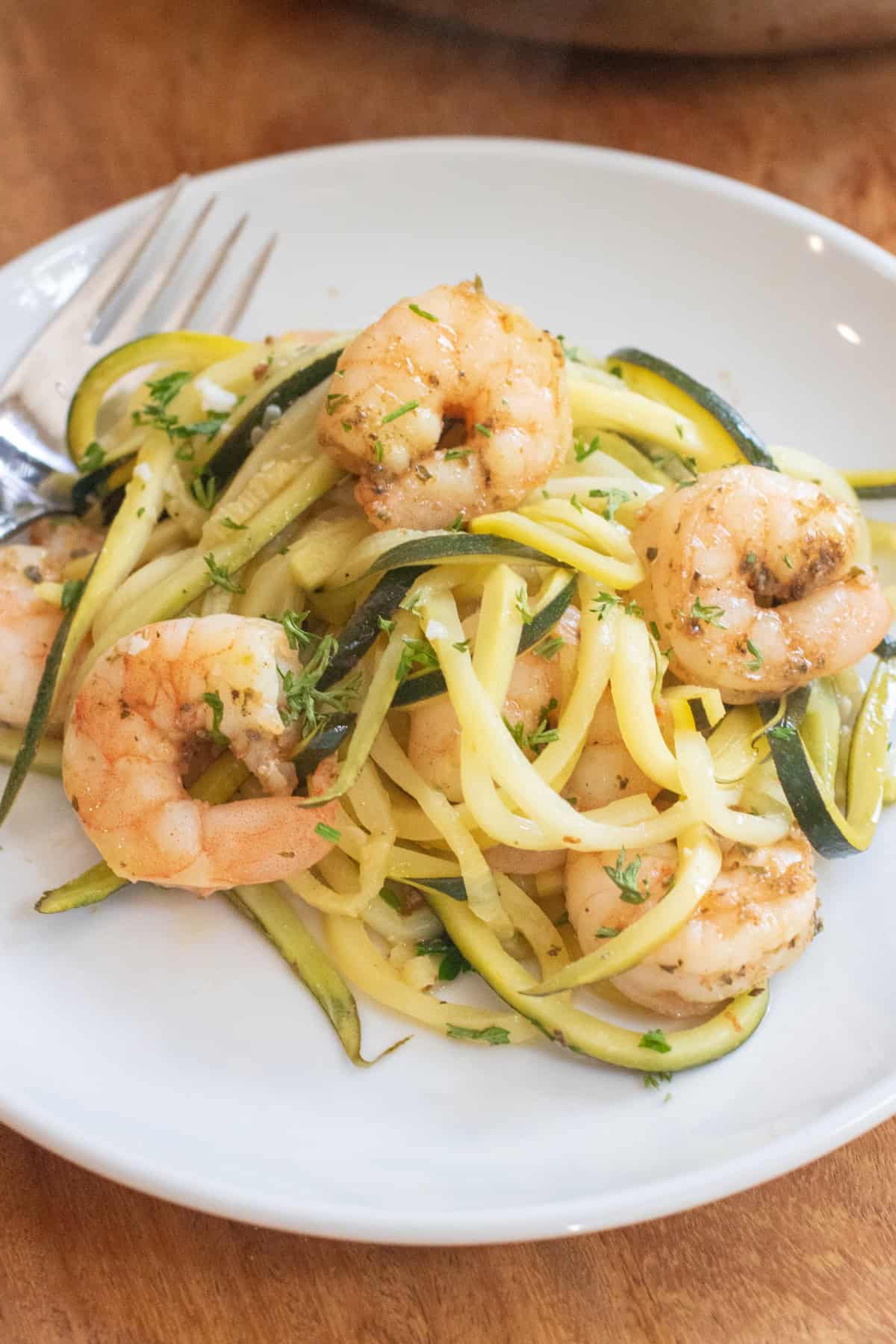 a plate of shrimp zoodle scampi with a fork.