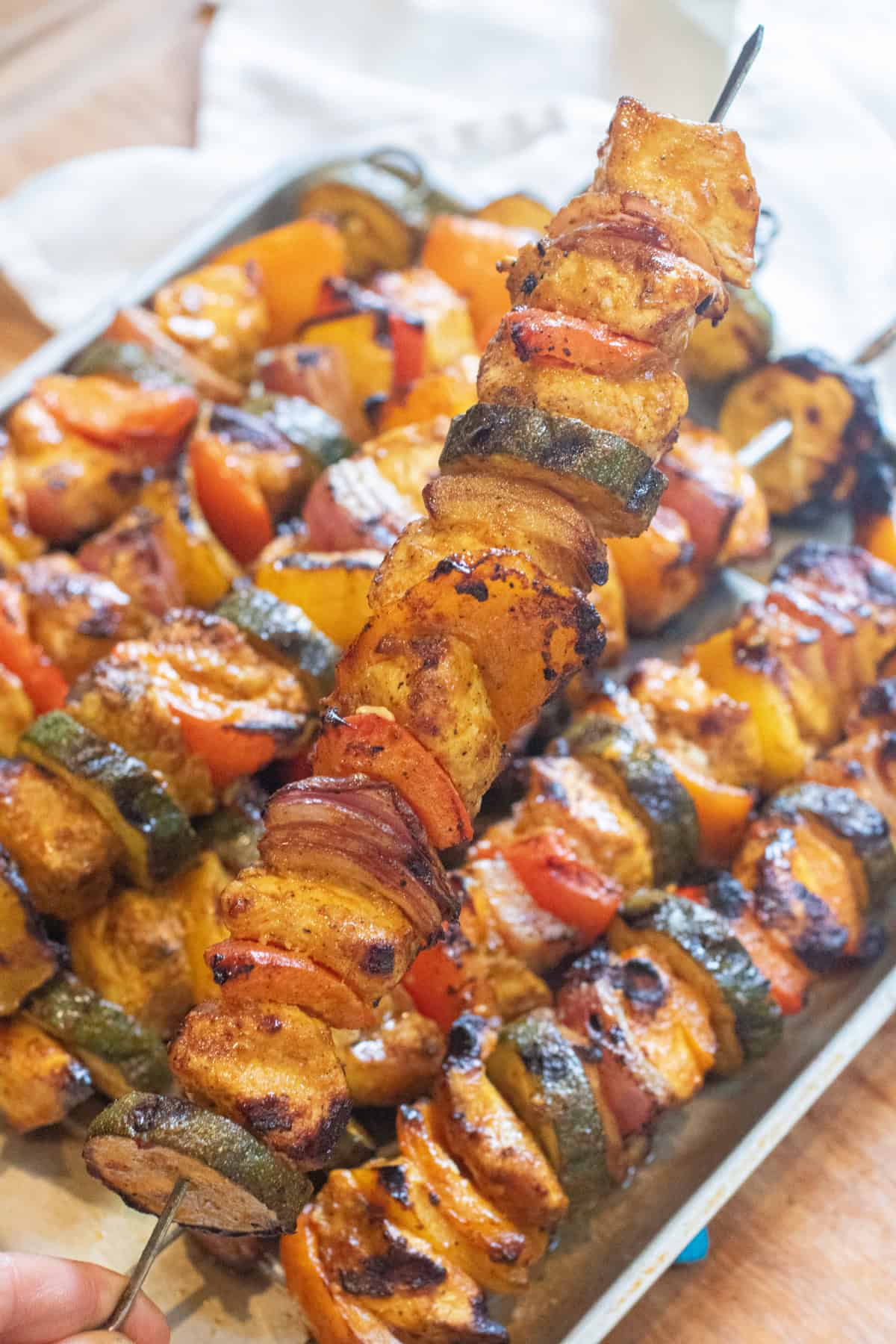 a tray of cooked chicken and pepper kebabs.
