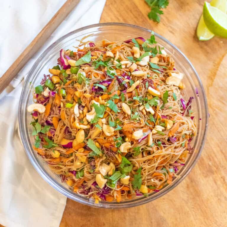 an overhead of a bowl of vermicelli noodles with veggies peanuts and cilantro.