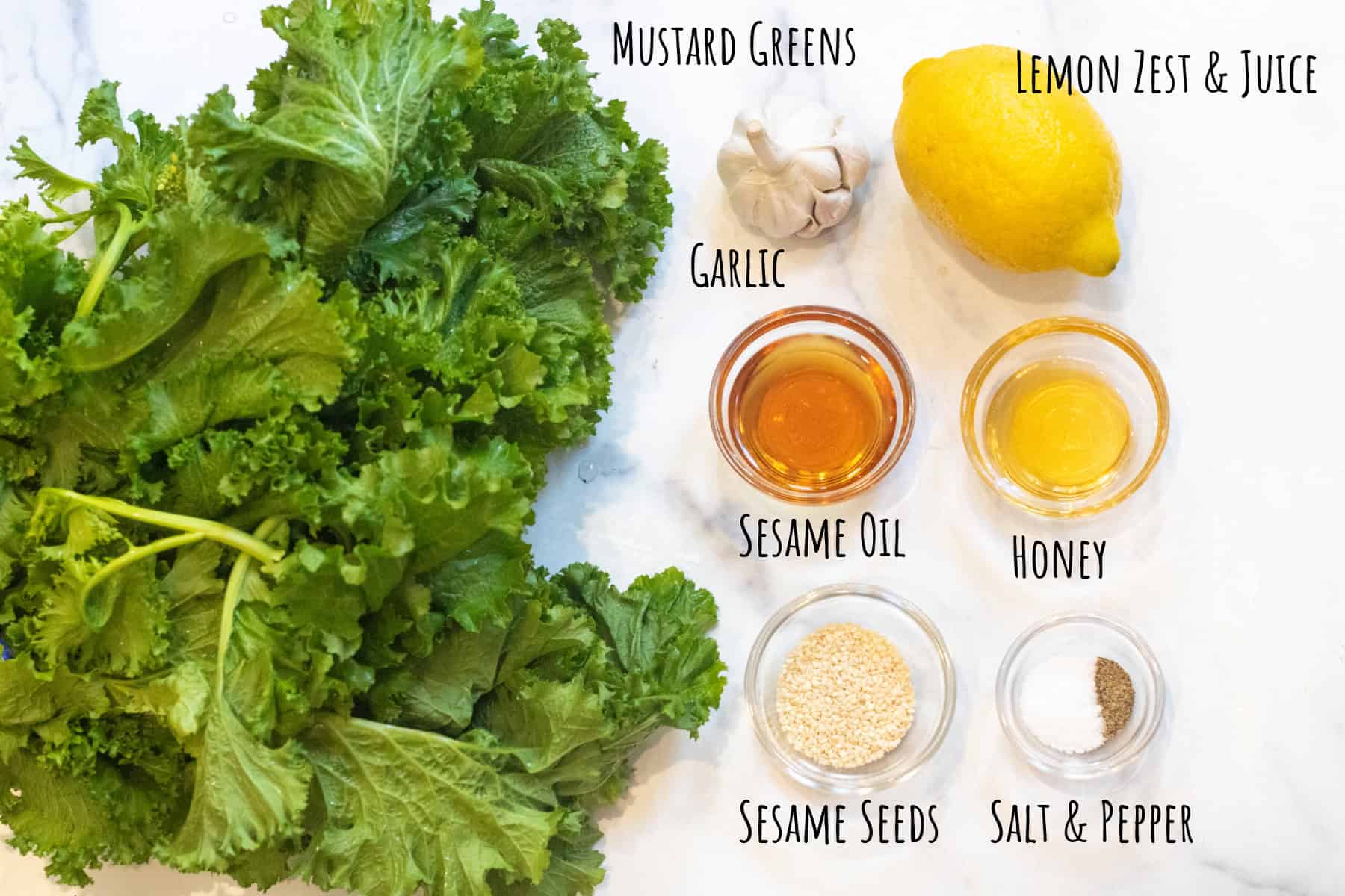 mustard greens, lemon, garlic, sesame oil, honey, sesame seeds, and salt and pepper in bowls and labeled.