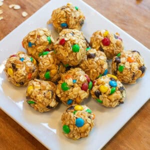 a tray of oat balls with raisins and m&ms.