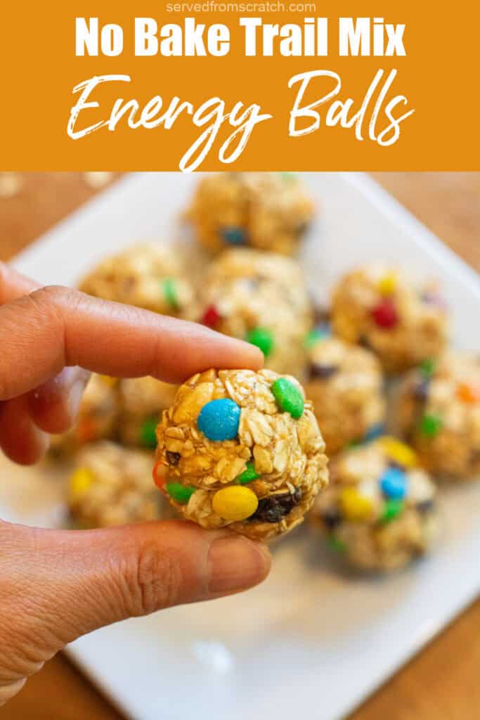 a hand holding an oat ball with m&ms, raisins, and nuts with Pinterest pin text.