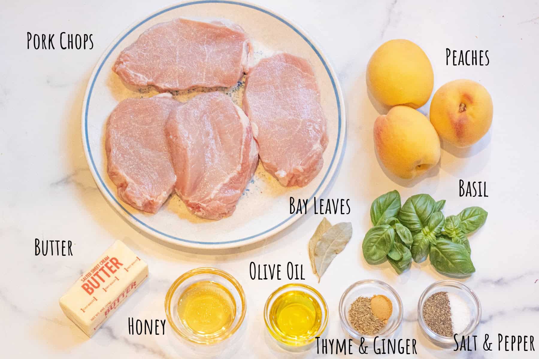 a plate of pork chops, peaches, basil, honey, butter, olive oil, bay leaves, dried thyme and ginger, and salt and pepper labeled.
