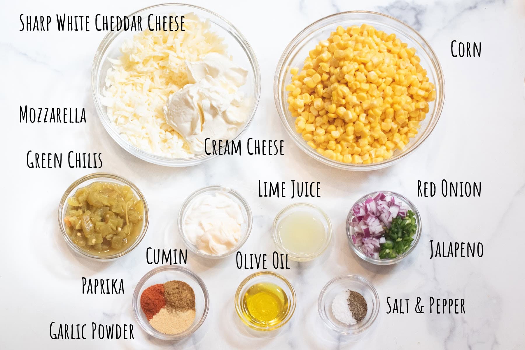 corn, cheeses, spices, chilis, mayo, sour cream, onion, and jalapeno diced in bowls and labeled.
