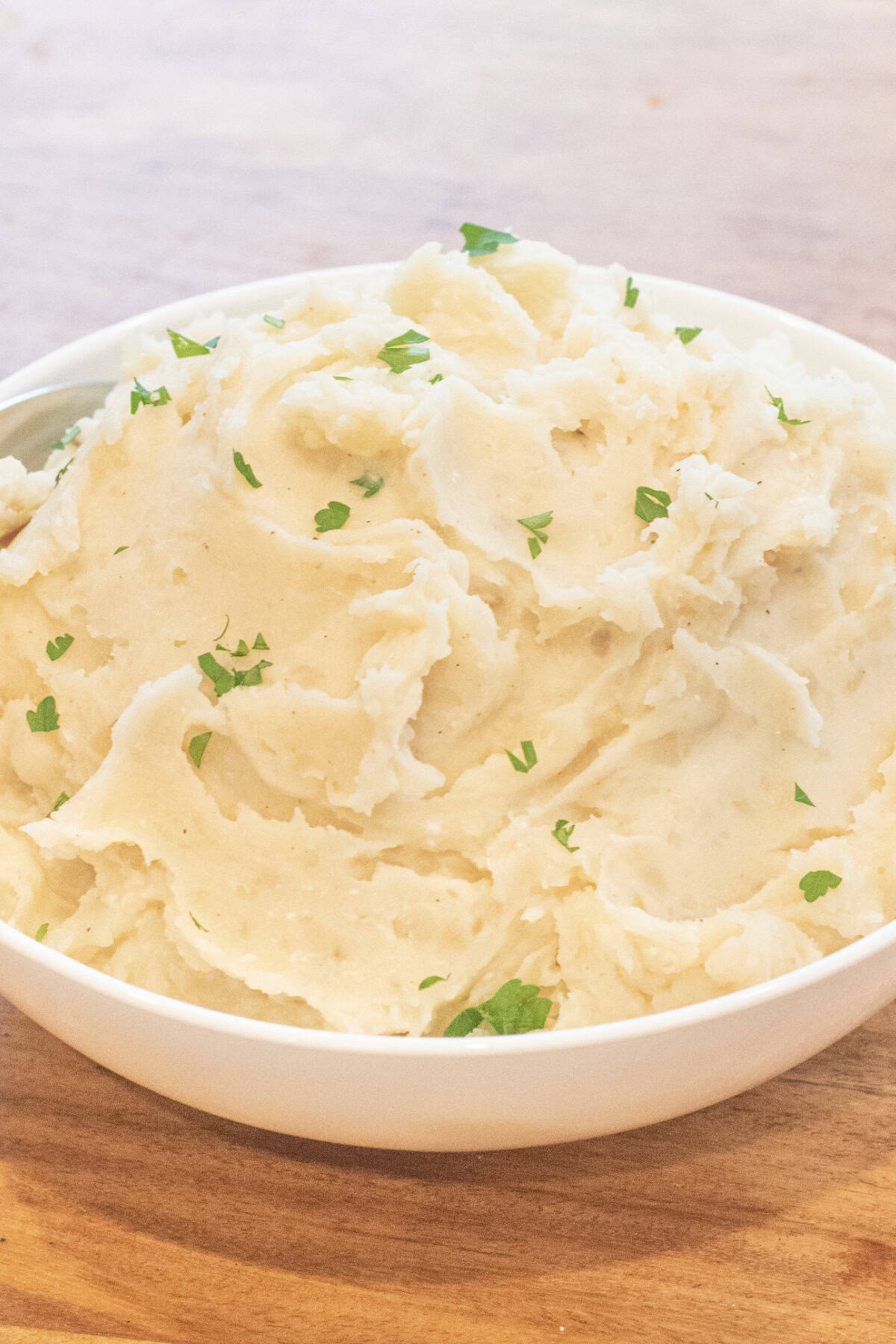 a bowl of creamy mashed potatoes with fresh parsley.