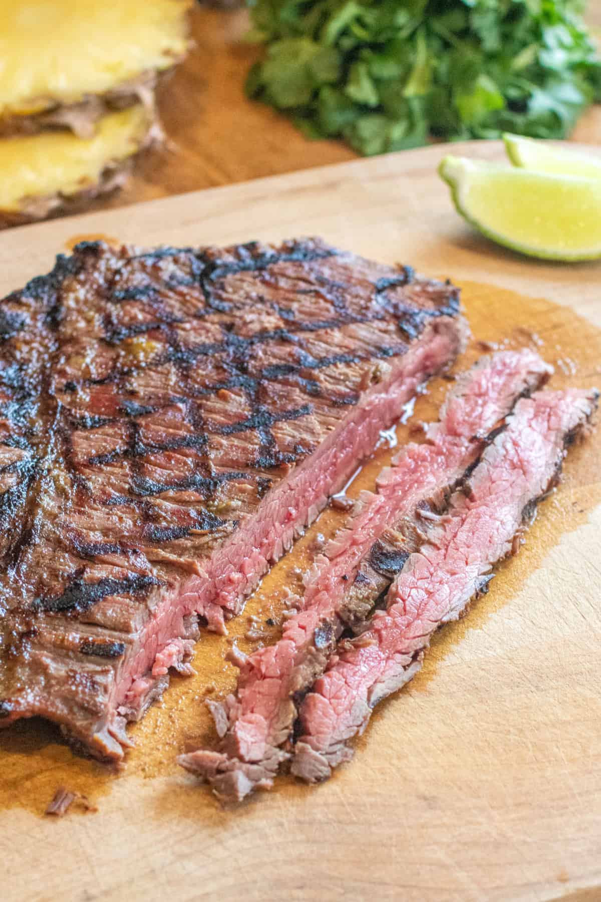 a grilled sliced flank steak on a cutting board.