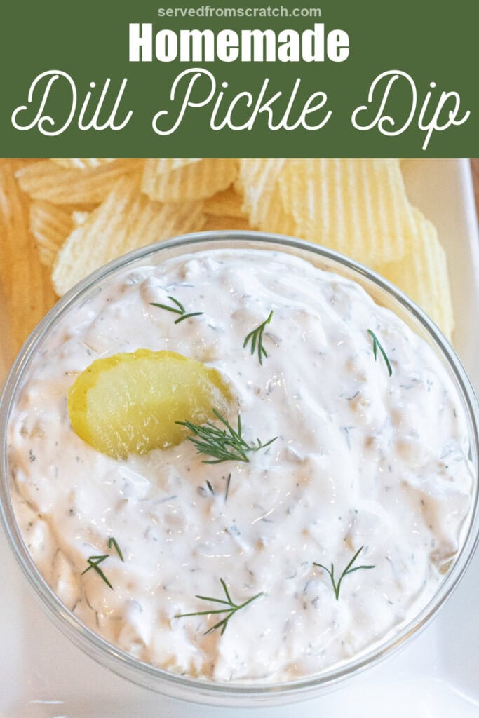 a bowl of creamy dip with a pickle and fresh dill on a plate of chips with Pinterest pin text.