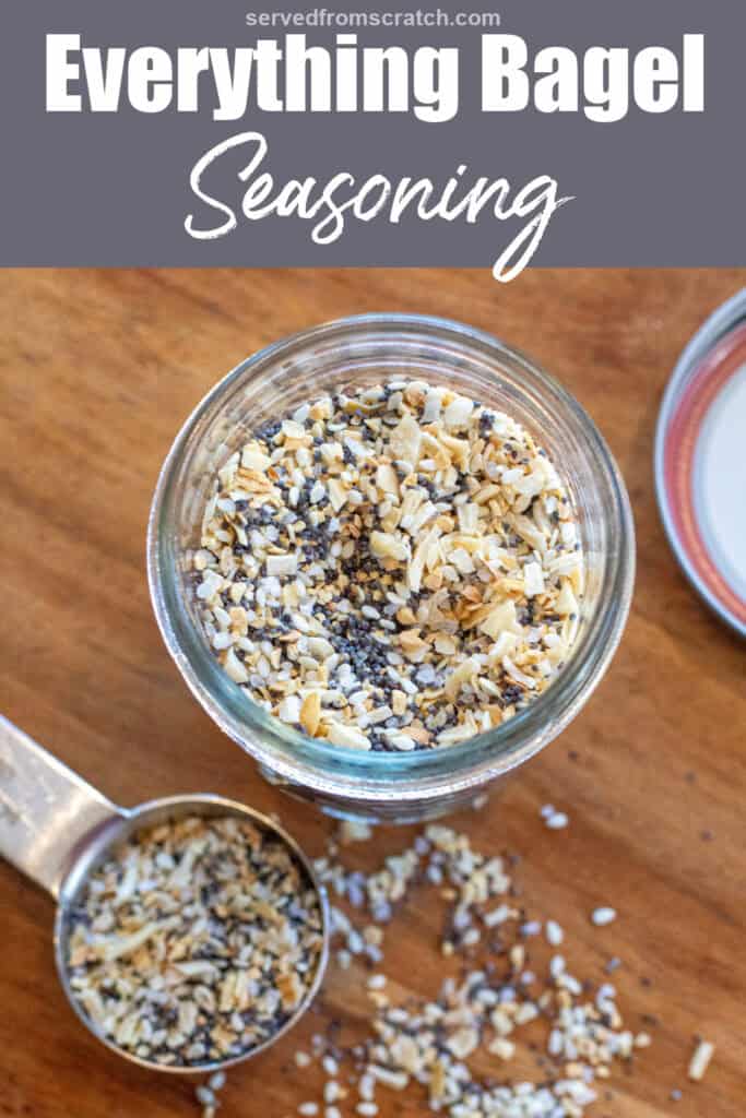 a labeled jar of everything bagel seasoning open with a tablespoon filled with seasoning next to it with Pinterest pin text.