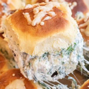 a cheesy slider filled with spinach artichoke dip.