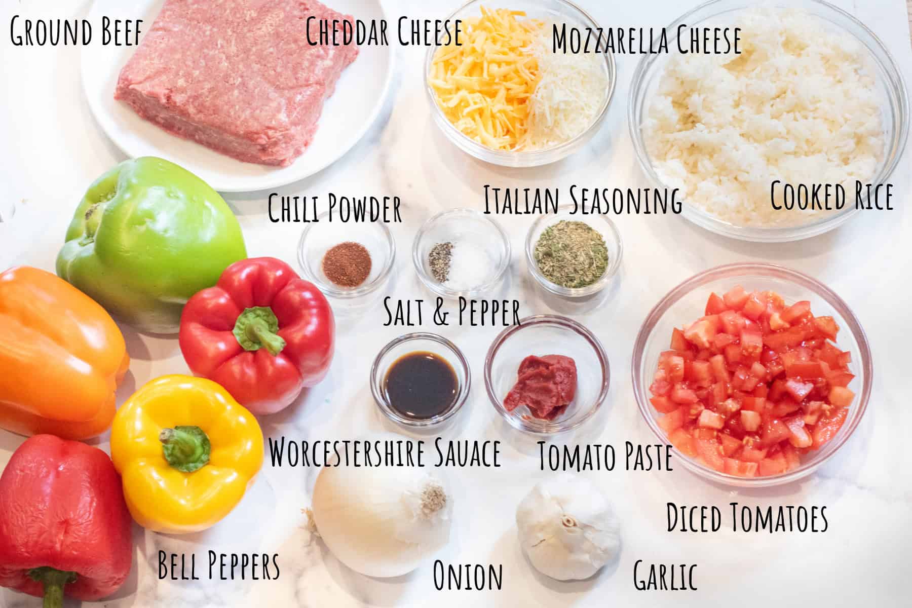 ground beef, bowls of cheese, spices, seasoning, diced tomatoes, rice, tomato paste, worcestshire sauce, and whole bell peppers, onion, and garlic bulb labeled.