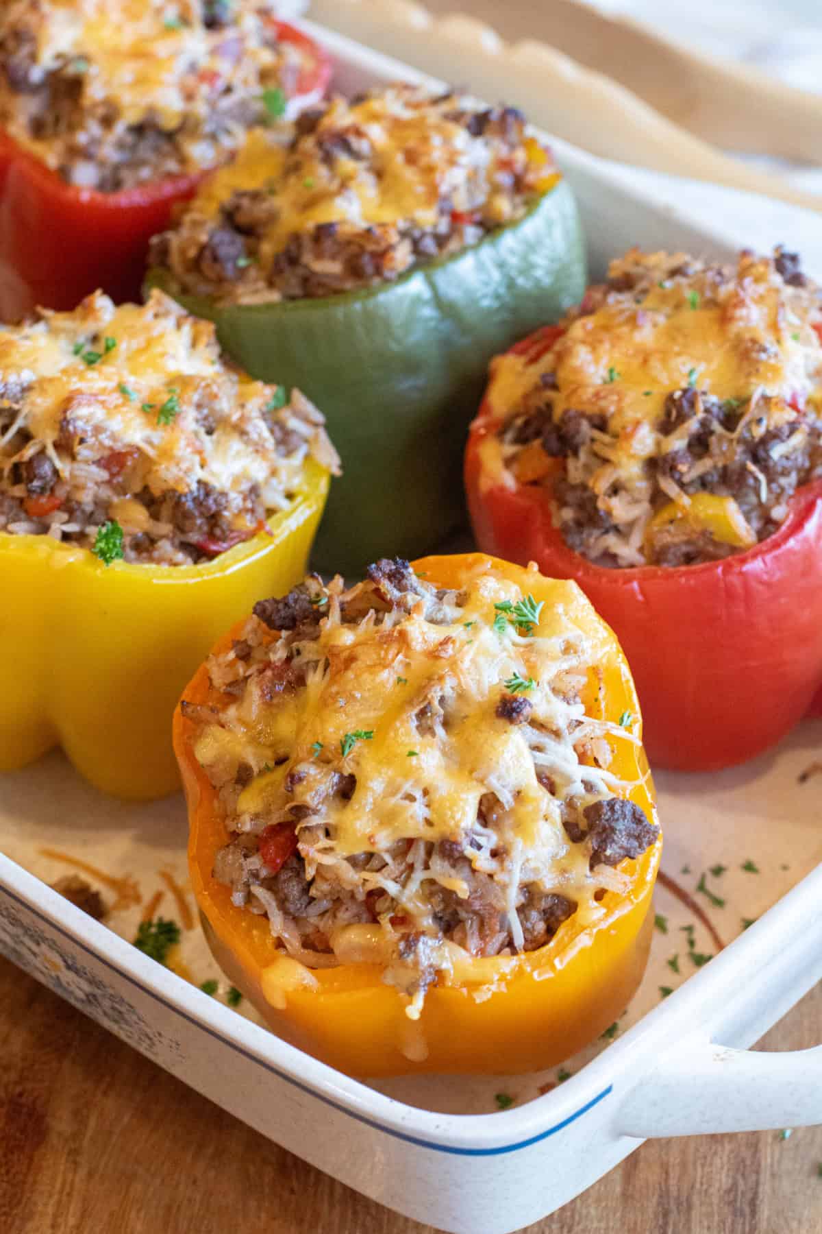 a tray of baked stuffed peppers with melted cheese on top.