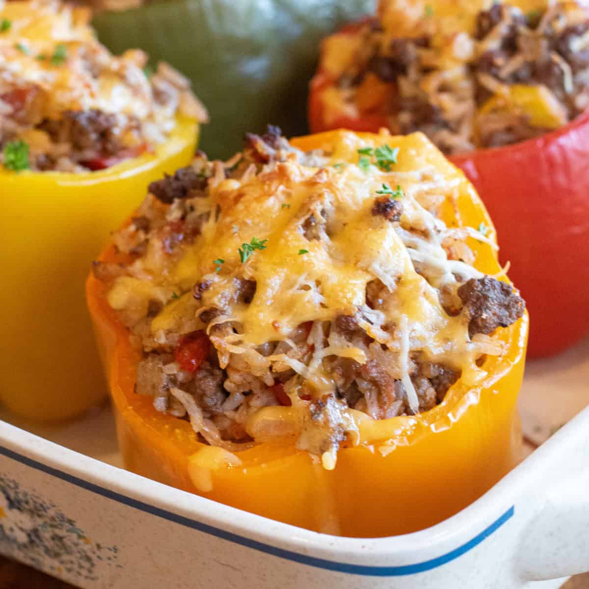 a close up of a orange stuffed pepper with ground beef, rice, and melted cheese.