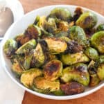 a large wide bowl of roasted and glazed brussels sprouts.