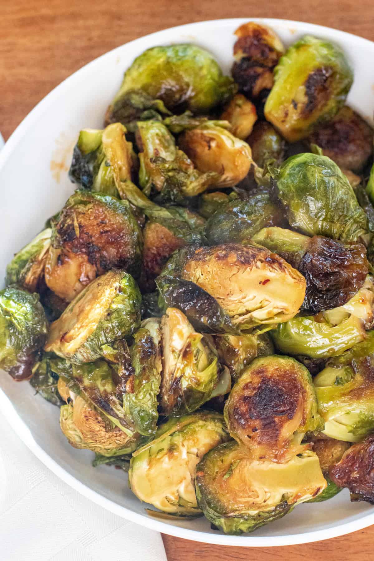 an overhead of a large wide bowl of roasted and glazed brussels sprouts.