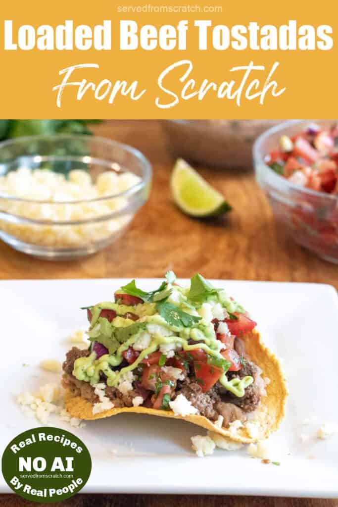 a loaded beef tostada on a plate with ground beef, cheese, pico, and a sauce, and Pinterest pin text with NO AI sticker.