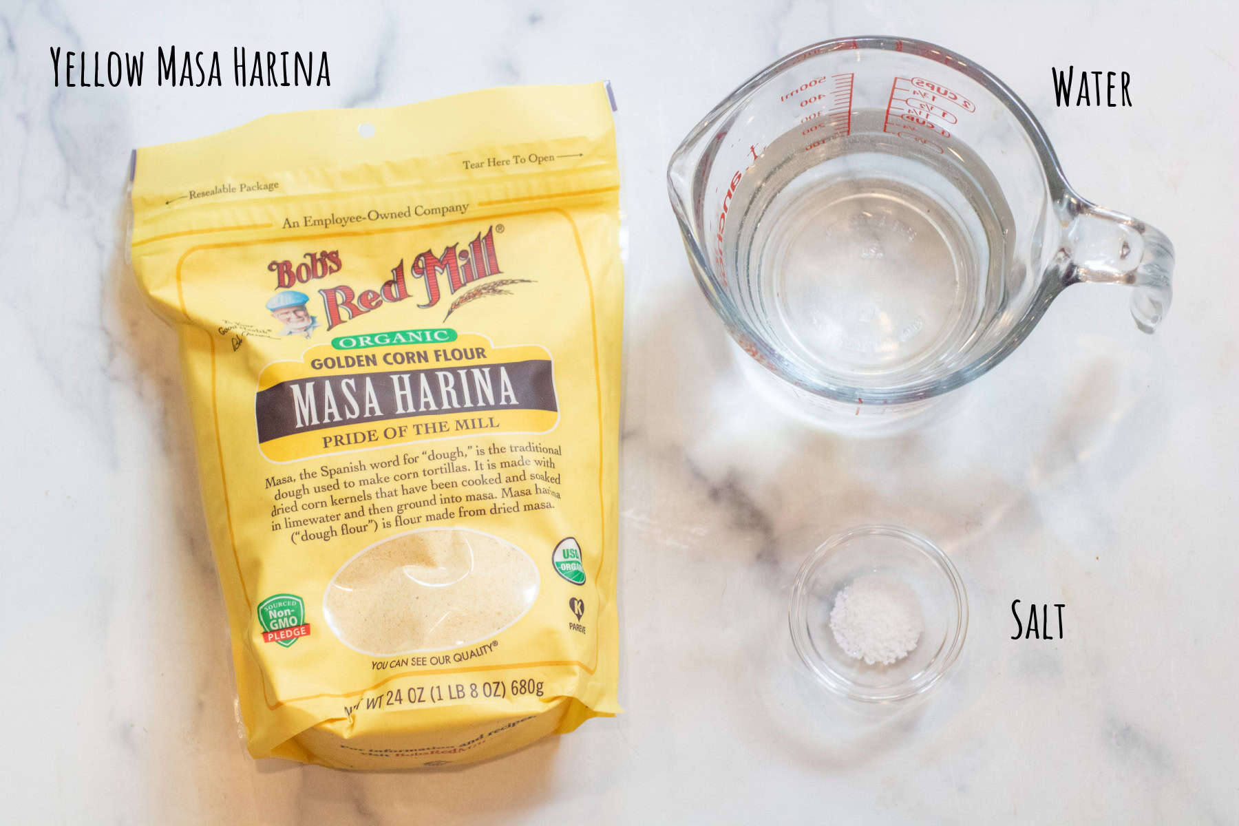 a bag of masa harina, pyrex of water, and a bowl of salt.