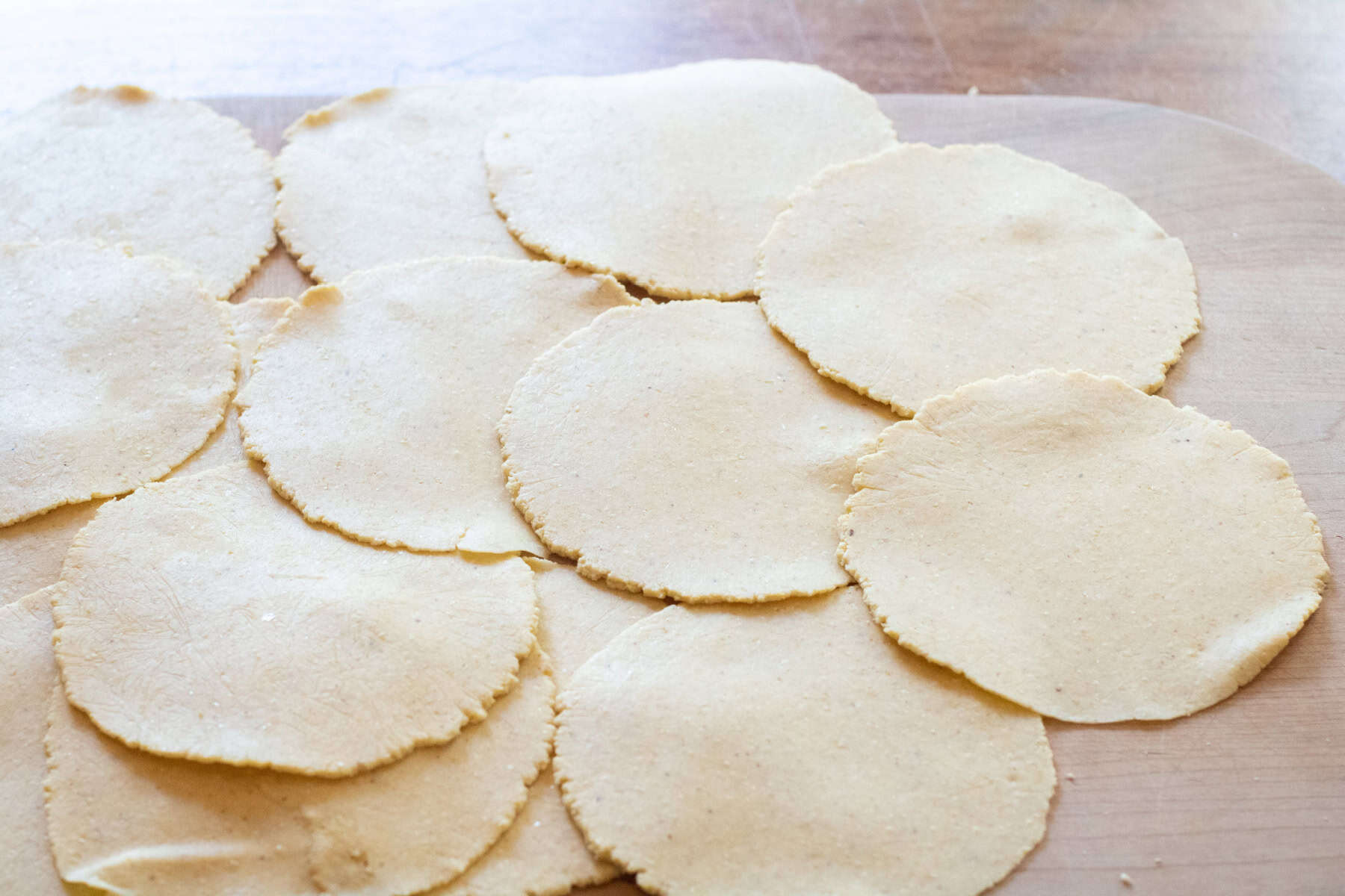 a cutting board of freshly pressed tortillas.