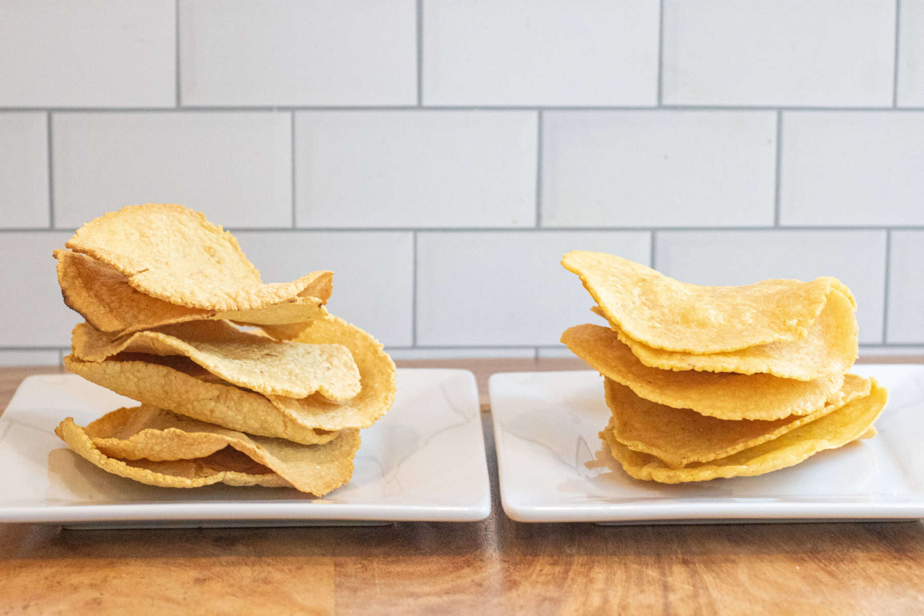 two plates of tostadas, one with baked and one with fried.